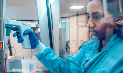 Researcher working in a laboratory using pipetting equipment.