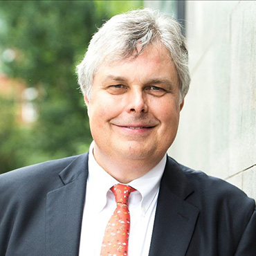 Profile of a mature man in a suit and tie smiling