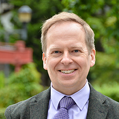 Profile of man wearing suit and tie, and smiling