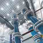 A set of tall high voltage power generators seen from below