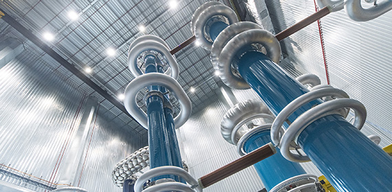 A set of tall high voltage power generators seen from below