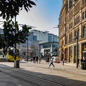 yellow tram crossing through city streets