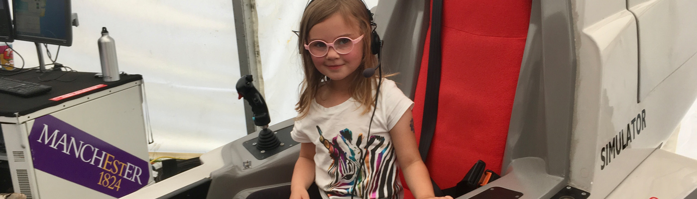 Young girl sat in flight simulator