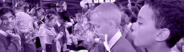 Children blowing bubble as part of a group experiment