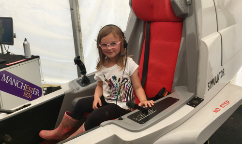 Young girl sat in flight simulator