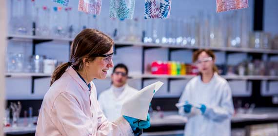 A lab technician holding a piece of cloth