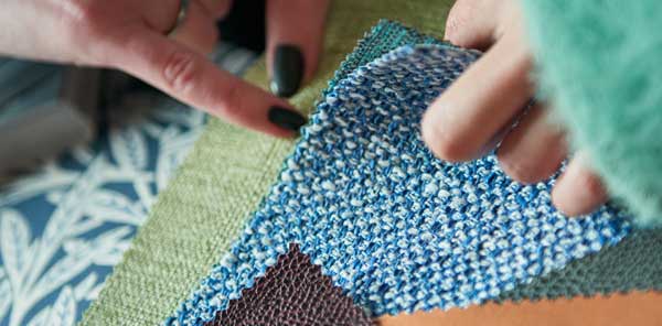 Close up of people flicking through material swatches
