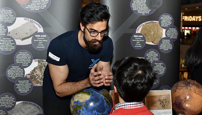 researchers talking to a small child at an event