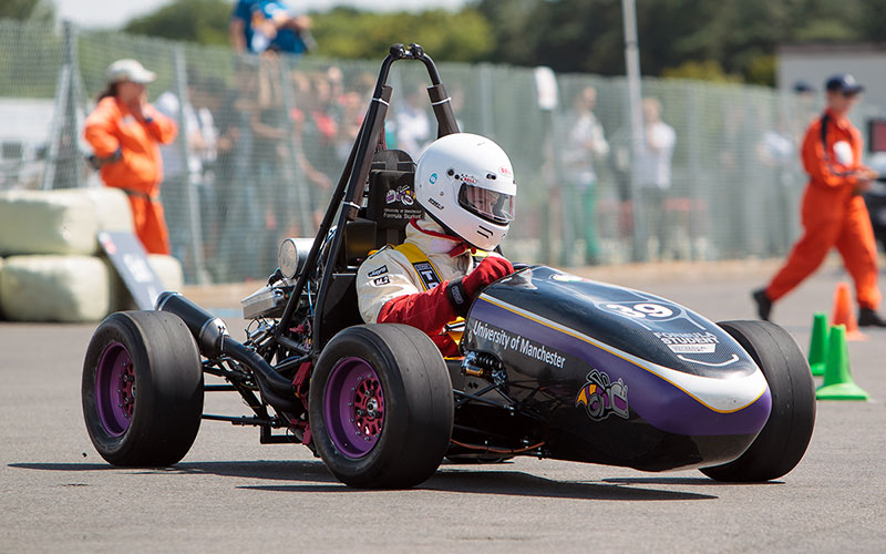 Student in a racing car project on a race track