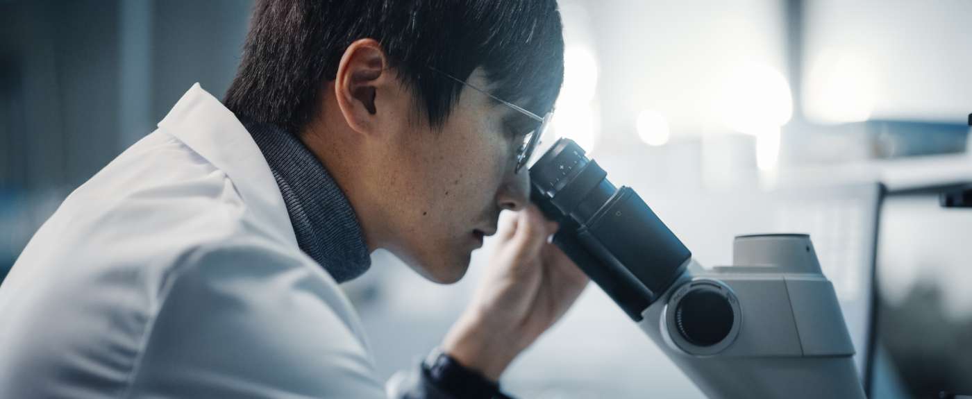Lab assistant using microscope