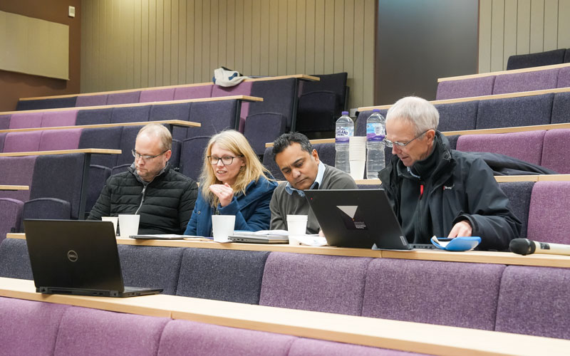 researchers with laptop computers in a lecture theatre