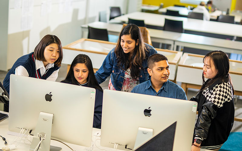 researchers gathered around a set of computer screens