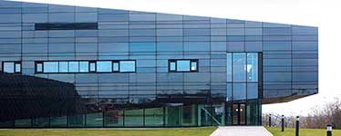 cuboid shaped black glass building with a slanted roof