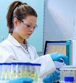 Female student in a lab next to test tubes
