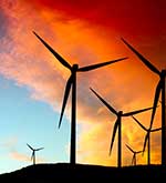 Wind turbines below a large bright orange cloud