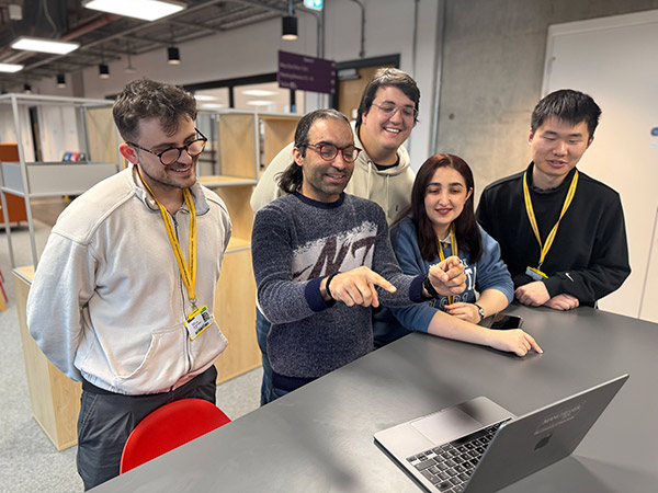 mechanics students gathered around a laptop