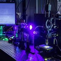 Photonics lab equipment illuminated in blue and green light
