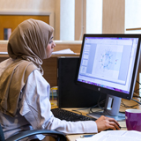 Female wearing head scarf working at computer