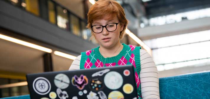 Female researcher sat looking down at her laptop