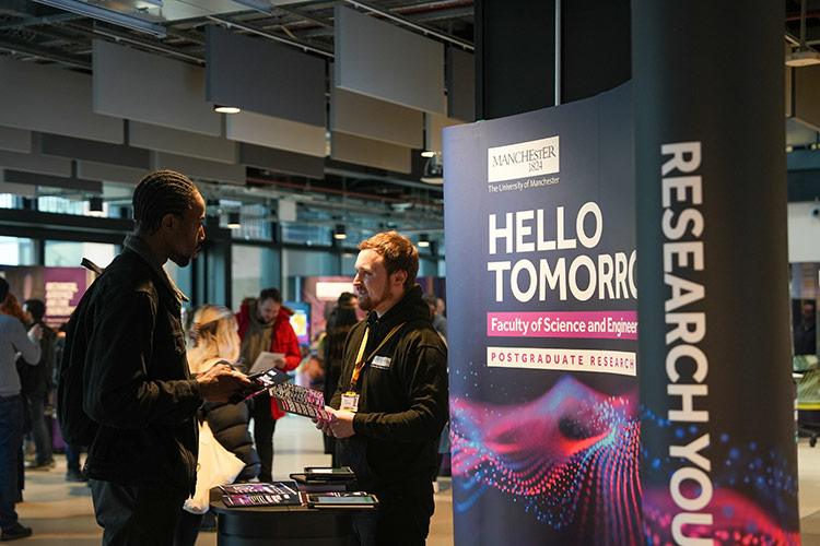 Prospective PhD student talking to a member of University staff at a postgraduate research open day